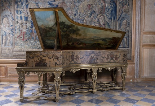 STEINWAY & SONS  Piano à queue modèle B, longueur : 211 cm  Longueur totale avec le décor : 282cm  88 notes, 3 pédales, cadre en fonte, cordes croisées.  Décor et piètement en copie du clavecin Rückers  conservé à Versailles, peint par Claude III  Audran.  Ce piano a reçu un coffrage à son extrémité  avec le décor de style Louis XIV à motifs  d’arabesques, guirlandes, amours musiciens,  muse musicienne et animaux sur fond doré. La  face interne du couvercle du piano est peinte  d’une scène pastorale à l’italienne, le piètement  doré à balustres.  Provenance : Charles Aznavour  Chanteur, compositeur et acteur mondialement  connu, Charles Aznavour a côtoyé au cours de sa  très longue carrière les plus grands artistes du XXe  siècle. Ces rencontres ont contribué à sa formation  culturelle et artistique.  “Chanteur de variété le plus important du XXe siècle”  selon le Times, et également grand amateur d'art, on  imagine la place particulière occupée par ce piano  dans sa propriété de Montfort-l'Amaury, comme en  témoigne la photo de Roger Kasparian (illustration  page précédente).  Dans un article du 3 février 1962 paru dans Paris  Match, Charles Aznavour évoque ce piano : “...pour  lui son luxe c'est le Steinway de ses débuts”.  A la fois instrument de travail et objet d’art, ce  piano a accompagné Charles Aznavour au cours de  son processus créatif.  L’histoire de Steinway débute en 1797 avec  Heinrich Engelhard Steinweg à Wolfshagen dans  le Harz. D’abord luthier, Steinweg fabrique son  premier piano en 1835 puis, après la révolution de  1848, les affaires devenant plus difficiles, il prend  la décision de traverser l’atlantique avec ses fils.  La famille américanise alors son nom en Steinway  et crée la firme Steinway & Sons à Manhattan en  1853. Une usine s’ouvre en Europe à Hambourg dès  1880. Les accords exceptionnels rendus possibles  par l’invention du cadre en fonte d’une seule pièce  et la nouveauté du croisement des cordes assurent  la popularité de la firme auprès des artistes et  amateurs du monde entier.  Dès 1857, Steinway ouvre un département Art case  qui permet de confier la décoration de pianos à  des artistes de renom qui s’inspirent des décors  de pianos anciens. Ces réalisations deviennent  le symbole d’une société mondaine aussi bien en  Europe qu’aux Etats-Unis et sont présentées lors  d’expositions internationales.  Le piano ici présenté reprend cette tradition par  son exceptionnelle décoration, reçue en copie  du clavecin de Ioannes Rückers (1578-1642),  aujourd’hui conservé à Versailles.  Un piano Steinway & Sons au décor semblable se  trouve à la Cathédrale Américaine de Paris. Il porte  le nom du compositeur américain Cole Porter qui  vécut à Paris entre 1917 et 1920.