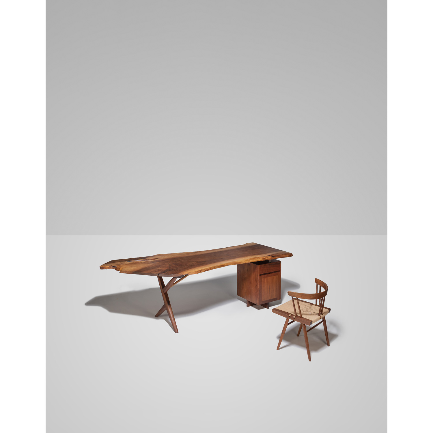 George Nakashima (1905-1990) Bureau et chaise (mod&egrave;le Seagrass) - Pi&egrave;ces uniques Noyer et herbier marin Mod&egrave;le cr&eacute;&eacute; en 1961 H 74,5 &times; L 236 &times; P 103 cm (bureau) H 70 &times; L 59,5 &times; P 49,5 cm (chaise) Commande sp&eacute;ciale pour M. Harris Levine, Clifton, New Jersey, USA. Une copie du bon de commande original pourra &ecirc;tre remise &agrave; l'acqu&eacute;reur.