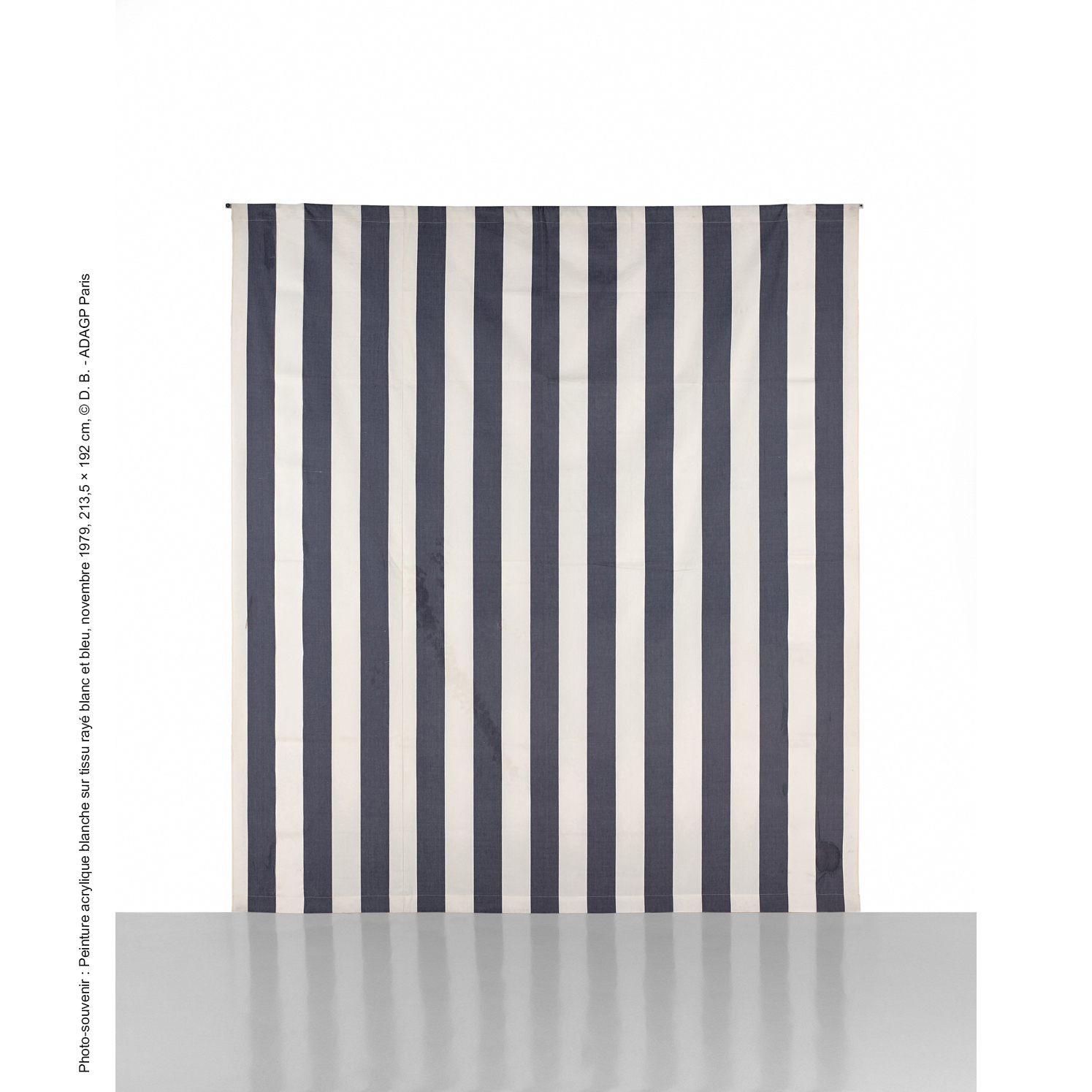 Daniel Buren (né en 1938)  Peinture acrylique blanche sur tissu rayé blanc et  bleu, novembre 1979  Acrylique blanche sur tissu rayé de bandes  blanches et bleues alternées et verticales, de 8,7  cm (+ 0,3) chacune  213,5 × 192 cm 