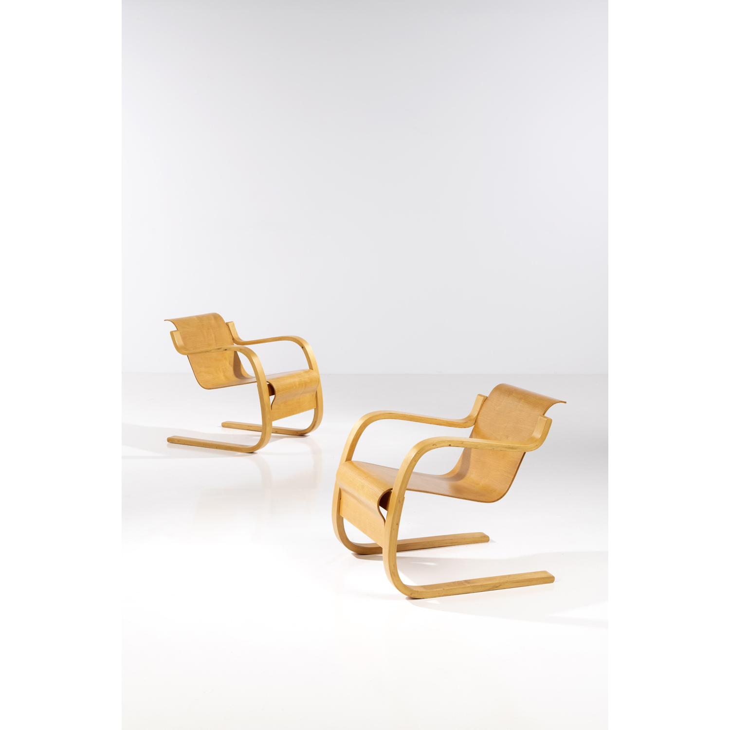 Alvar Aalto (1898-1976) Model n°31, 'Cantilever' Pair of armchairs Birch wood Edited by Huonekalu-ja Rakennustyötehdas Oy Tampon 'AALTO DESIGNER MADE IN FINLAND' beneath one crosspiece Model created in 1932 H 70 x L 60,5 x P 72 cm Bibliography: - Alvar Aalto Furniture, J. Pallasmaa, Museum of Finnish Architecture Finnish Society of Crafts and Design Artek, 1984, similar models pp.12, 76, 80, 86-89, 91, 126, 132-33 - Alvar Aalto Designer, P. Tuukkanen, Vammala, 2002, similar models pp.18, 71, 160, 165 - Alvar Aalto: Second Nature, J. Eisenbrand and M. Kries, Vitra Design Museum, 2014, similar model pp. 520-521