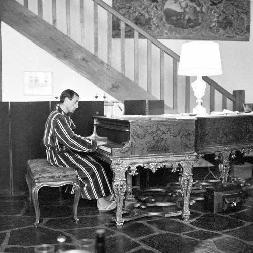 STEINWAY & SONS  Piano à queue modèle B, longueur : 211 cm  Longueur totale avec le décor : 282cm  88 notes, 3 pédales, cadre en fonte, cordes croisées.  Décor et piètement en copie du clavecin Rückers  conservé à Versailles, peint par Claude III  Audran.  Ce piano a reçu un coffrage à son extrémité  avec le décor de style Louis XIV à motifs  d’arabesques, guirlandes, amours musiciens,  muse musicienne et animaux sur fond doré. La  face interne du couvercle du piano est peinte  d’une scène pastorale à l’italienne, le piètement  doré à balustres.  Provenance : Charles Aznavour  Chanteur, compositeur et acteur mondialement  connu, Charles Aznavour a côtoyé au cours de sa  très longue carrière les plus grands artistes du XXe  siècle. Ces rencontres ont contribué à sa formation  culturelle et artistique.  “Chanteur de variété le plus important du XXe siècle”  selon le Times, et également grand amateur d'art, on  imagine la place particulière occupée par ce piano  dans sa propriété de Montfort-l'Amaury, comme en  témoigne la photo de Roger Kasparian (illustration  page précédente).  Dans un article du 3 février 1962 paru dans Paris  Match, Charles Aznavour évoque ce piano : “...pour  lui son luxe c'est le Steinway de ses débuts”.  A la fois instrument de travail et objet d’art, ce  piano a accompagné Charles Aznavour au cours de  son processus créatif.  L’histoire de Steinway débute en 1797 avec  Heinrich Engelhard Steinweg à Wolfshagen dans  le Harz. D’abord luthier, Steinweg fabrique son  premier piano en 1835 puis, après la révolution de  1848, les affaires devenant plus difficiles, il prend  la décision de traverser l’atlantique avec ses fils.  La famille américanise alors son nom en Steinway  et crée la firme Steinway & Sons à Manhattan en  1853. Une usine s’ouvre en Europe à Hambourg dès  1880. Les accords exceptionnels rendus possibles  par l’invention du cadre en fonte d’une seule pièce  et la nouveauté du croisement des cordes assurent  la popularité de la firme auprès des artistes et  amateurs du monde entier.  Dès 1857, Steinway ouvre un département Art case  qui permet de confier la décoration de pianos à  des artistes de renom qui s’inspirent des décors  de pianos anciens. Ces réalisations deviennent  le symbole d’une société mondaine aussi bien en  Europe qu’aux Etats-Unis et sont présentées lors  d’expositions internationales.  Le piano ici présenté reprend cette tradition par  son exceptionnelle décoration, reçue en copie  du clavecin de Ioannes Rückers (1578-1642),  aujourd’hui conservé à Versailles.  Un piano Steinway & Sons au décor semblable se  trouve à la Cathédrale Américaine de Paris. Il porte  le nom du compositeur américain Cole Porter qui  vécut à Paris entre 1917 et 1920.