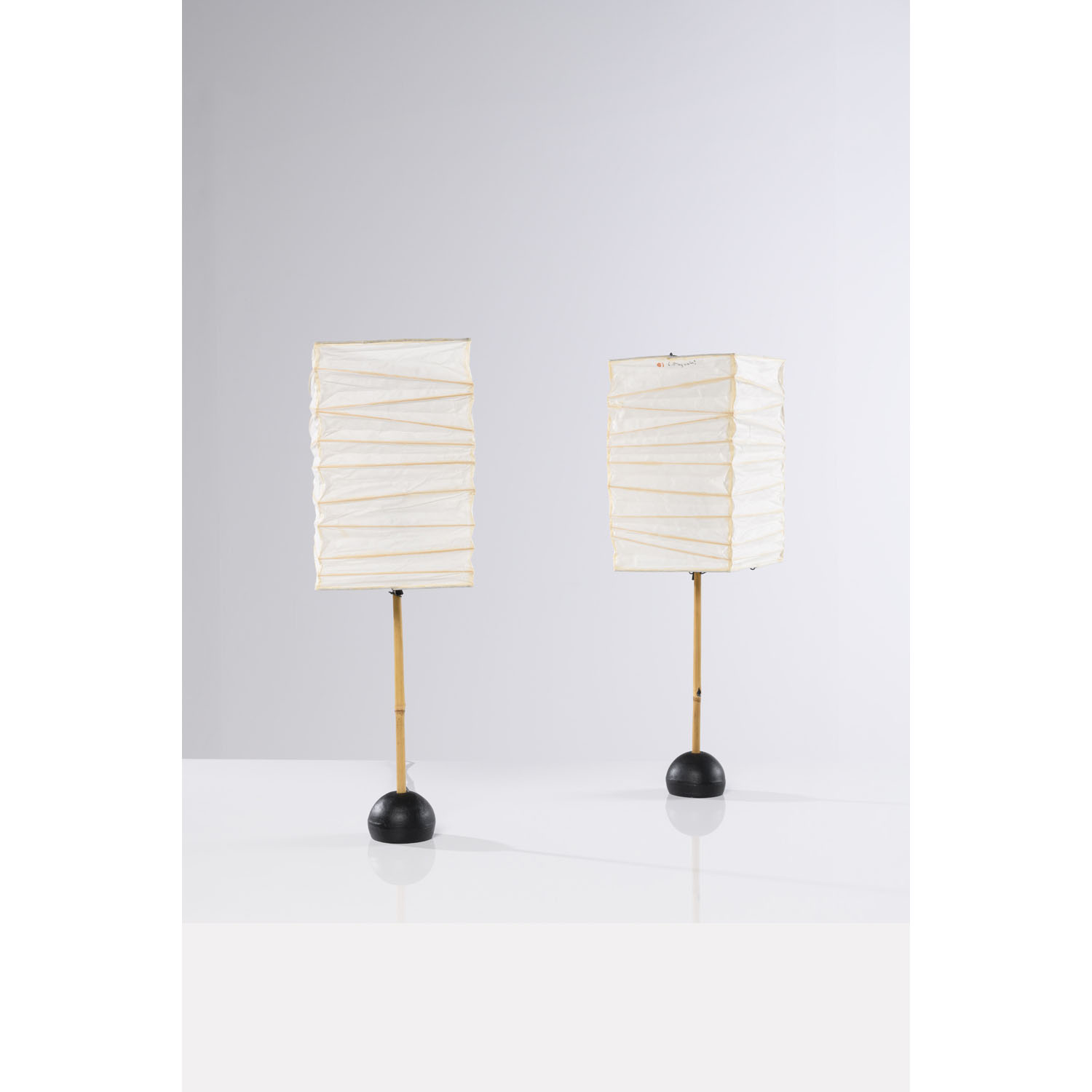 Isamu Noguchi (1904-1988) Mod&egrave;le n&deg; BB1-30XN Estimation : 4000 / 6000 &euro; Isamu Noguchi (1904-1988)  Mod&egrave;le n&deg; BB1-30XN  Paire de lampes de tables  Papier washi, m&eacute;tal laqu&eacute; noir et bambou  &Eacute;dition Ozeki  Id&eacute;ogramme rouge 'Soleil et Lune' et signature  Date de cr&eacute;ation : 1978  H 61 &times; L 20 &times; P 20 cm  Base : &Oslash; 9 cm