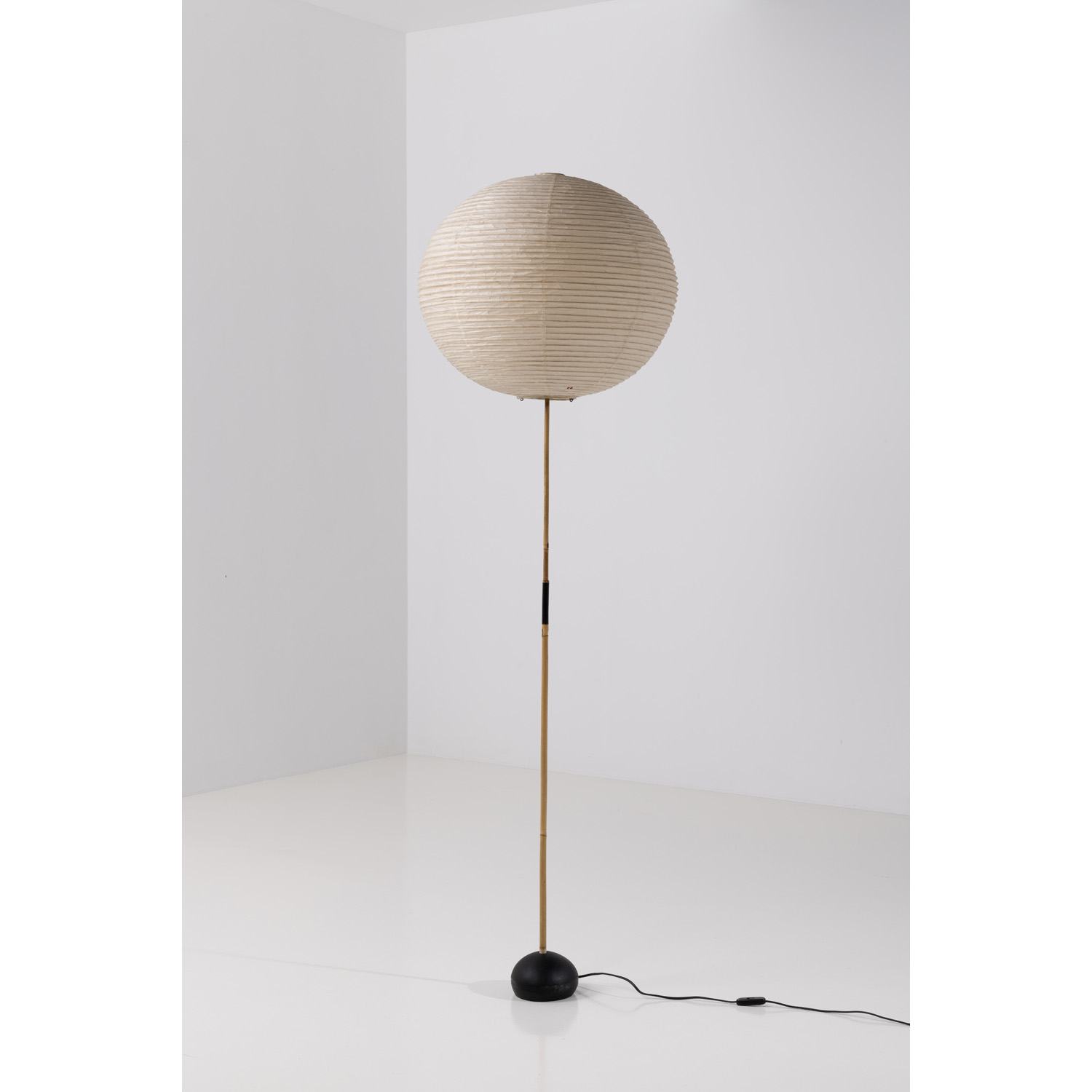 Isamu Noguchi (1944-1988) S&eacute;rie Akari Lampadaire mod&egrave;le BB3-55A Papier washi, bambou, m&eacute;tal laqu&eacute; et fonte d'aluminium &Eacute;dition Ozeki Id&eacute;ogramme rouge dit 'Soleil et Lune' sur l'abat- jour, la base avec inscription incis&eacute;e sur l'envers 'MADE IN JAPAN' Mod&egrave;le cr&eacute;&eacute; en 1979 H 175 &times; &Oslash; 50 cm Bibliographie : Akari, les chemins de la lumi&egrave;re, P.Briellard, C. Magnan et T. Varaillon, catalogue d'exposition, Wa Design Gallery, 2021, mod&egrave;le similaire p. 172-173