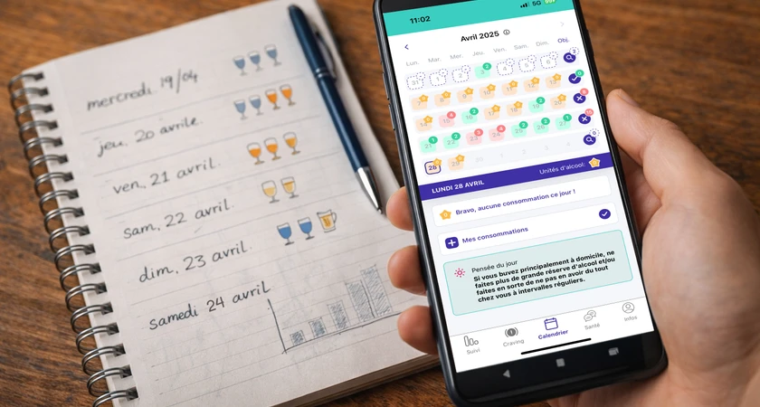 Calendrier de suivi de consommation d'alcool sur un téléphone, avec un carnet annoté en arrière-plan.