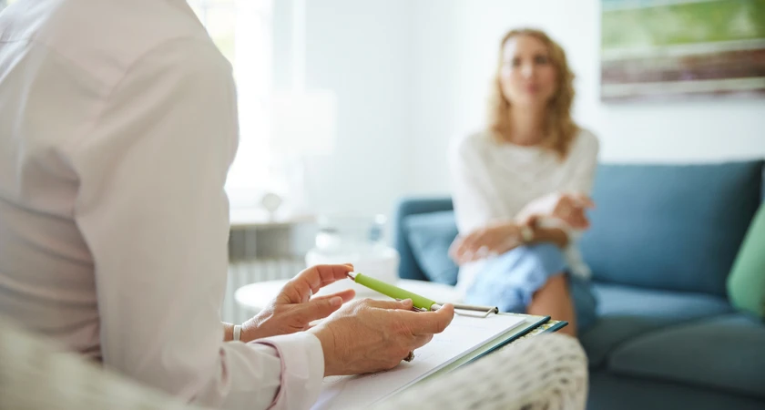 Consultation entre une thérapeute et une patiente dans un cabinet lumineux.