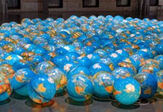 Multitude de ballons représentant la Terre posés au sol.