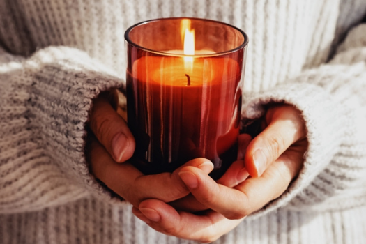 A lighted Candle held between two hands