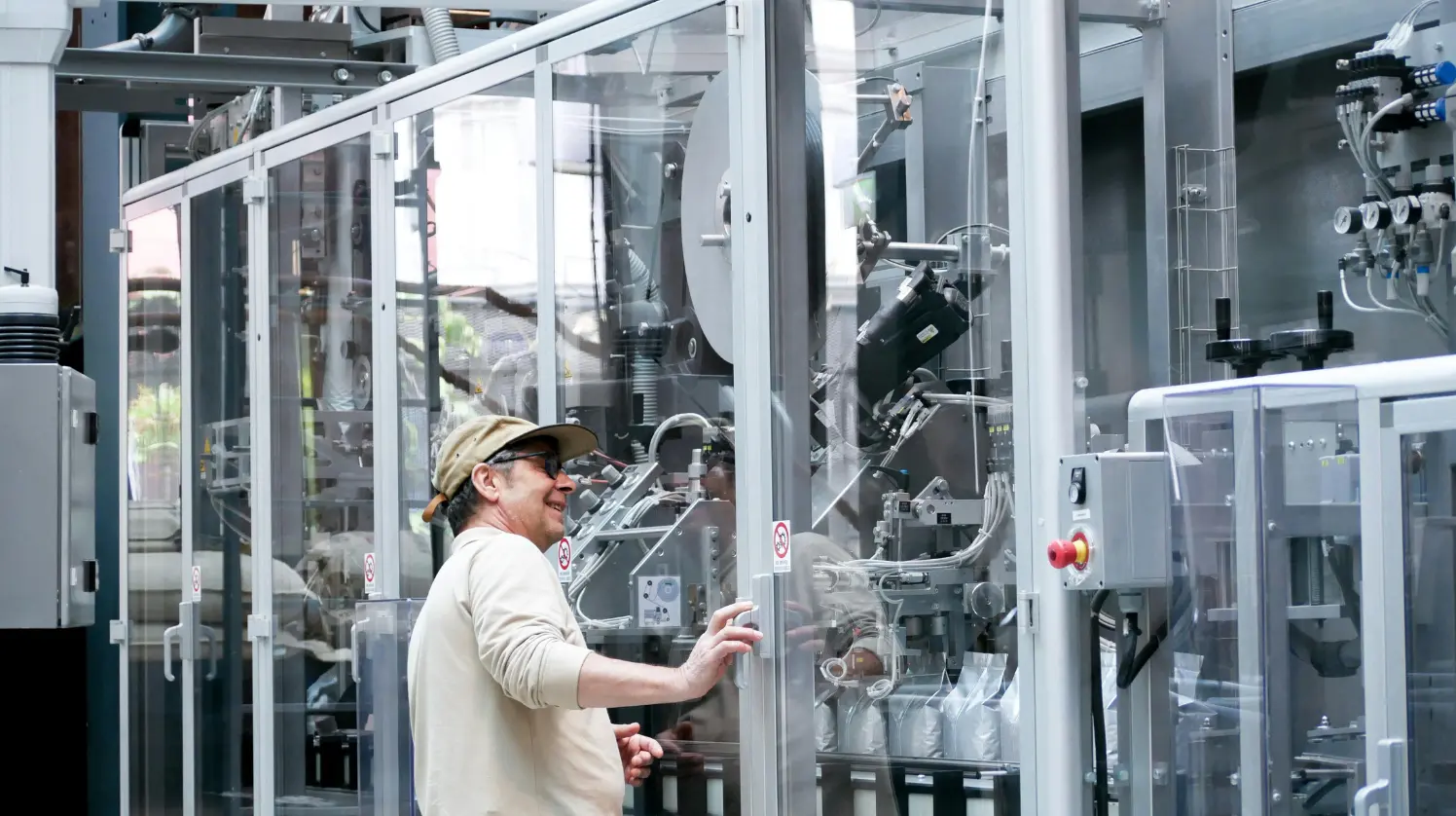 Un ingénieur dans une usine de fabrication inspecte une grande machine afin de vérifier sa sécurité et son bon fonctionnement.