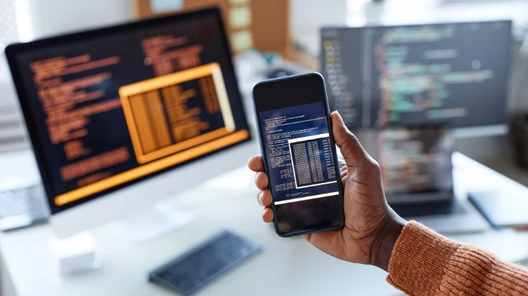 A developer is working on a low code application development system and tries different adds on a phone, a tablet, and a laptop