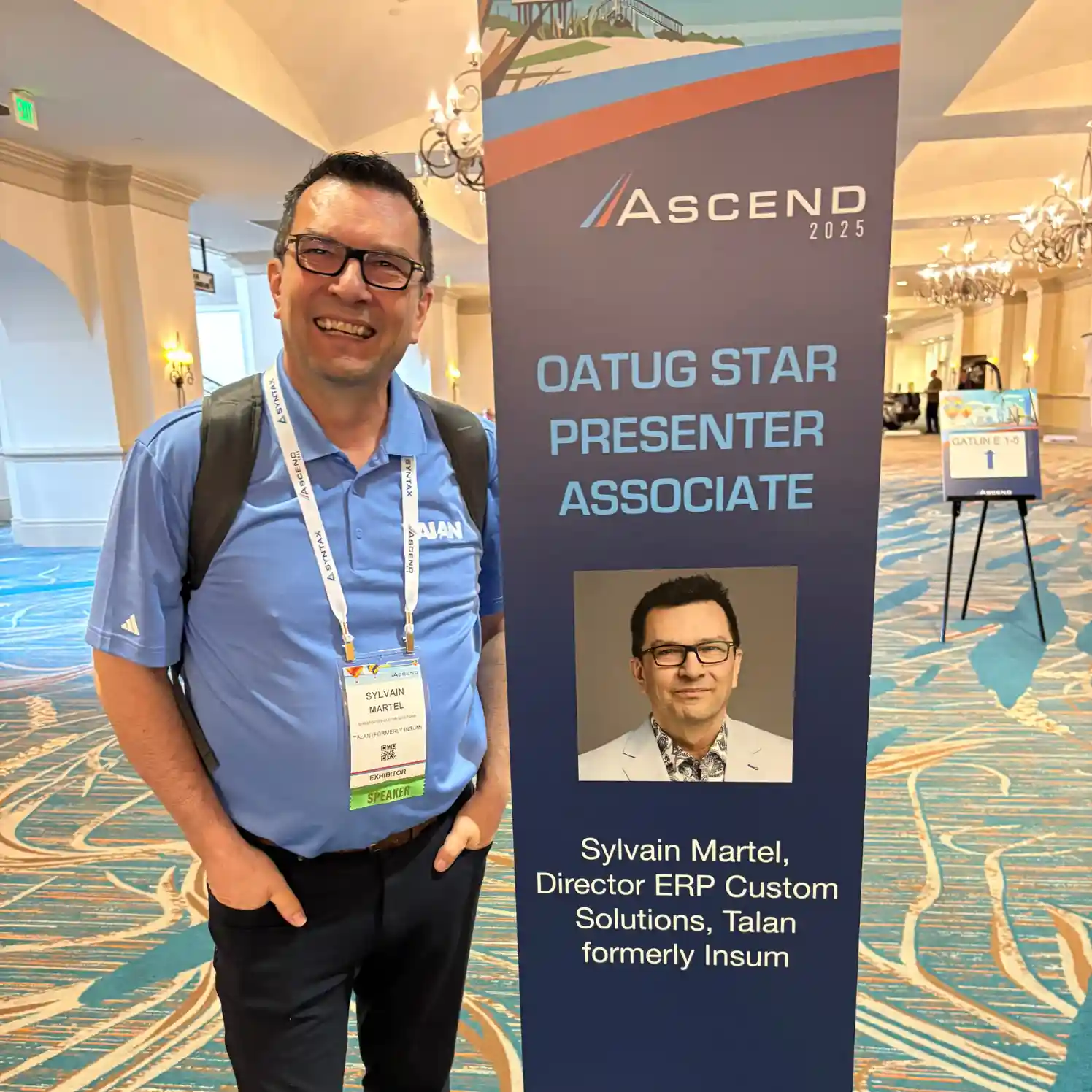 Sylvain at the Ascend2025 next to a poster of himself