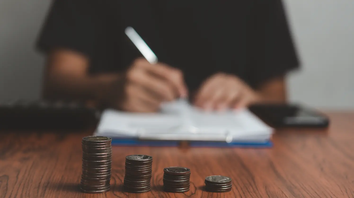 A man is calculating the cost of a project by using a calculator 