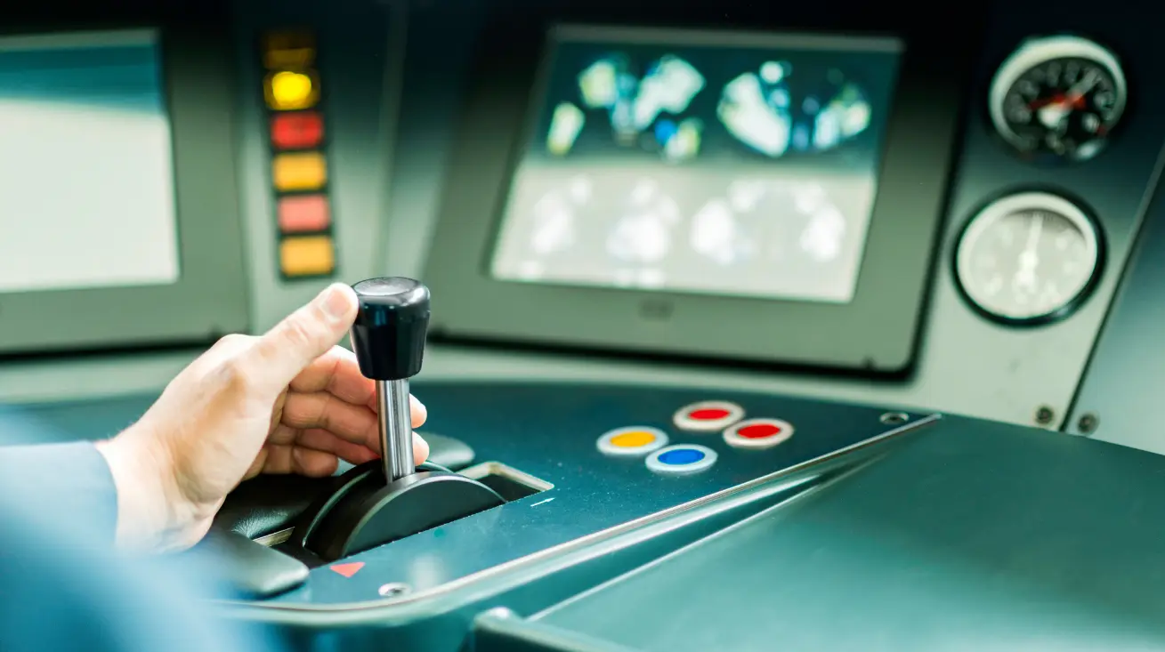 A conductor in the driver cabin of a modern train drives the train towards its destination