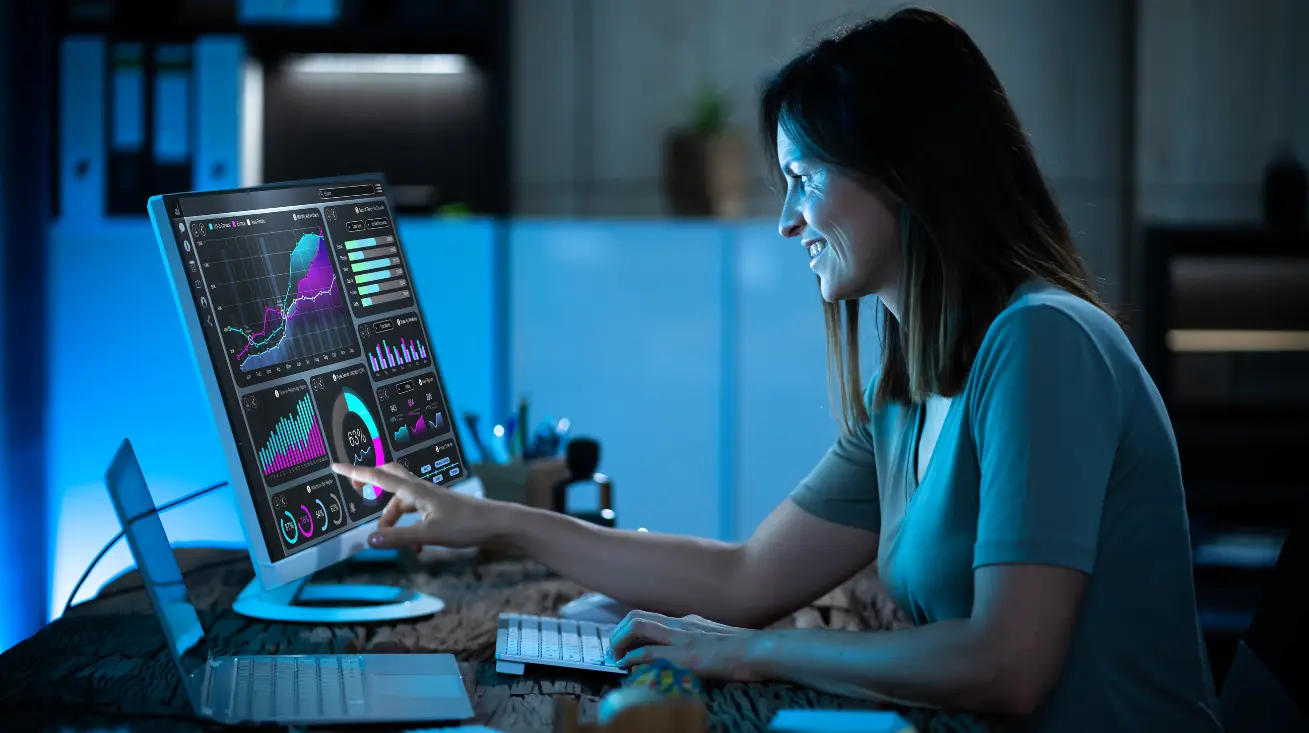 A data engineer is analyzing reports on a computer with futuristic interface