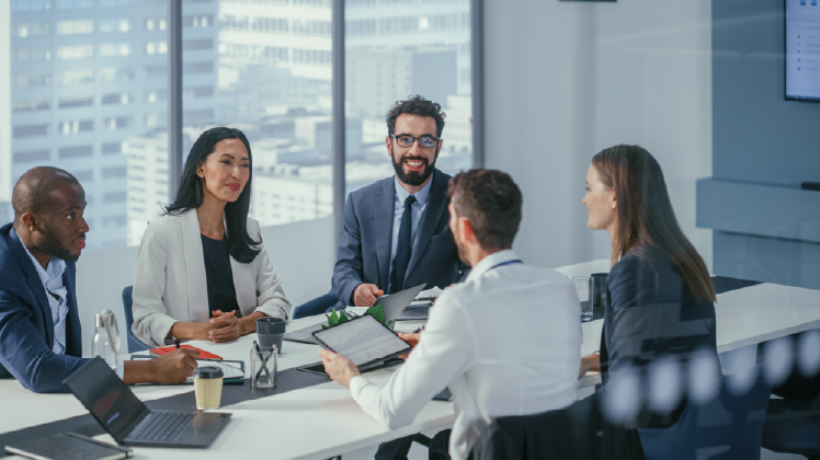 Group of finance professionals analyzing in an office with digital dashboard and computers.