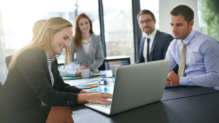 Team of people looking at a computer with SAP's business intelligence solutions.