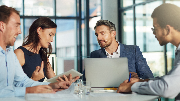 Équipe de personnes regardant un ordinateur équipé de solutions SAP de veille stratégique.