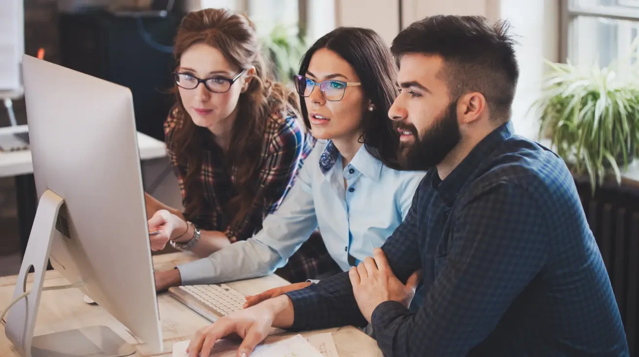 A group of employees in an office are looking at a complex coputer system