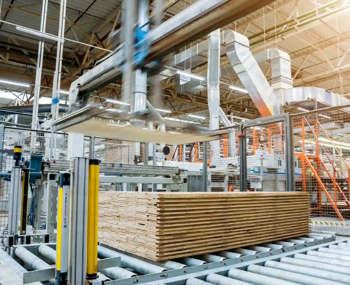 Indoor manufacturing plant with large machines and wood that will be milled.