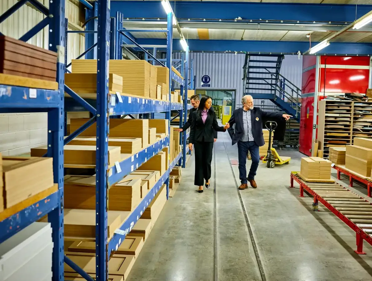 Two business managers walk an organized shop floor and inspect the process