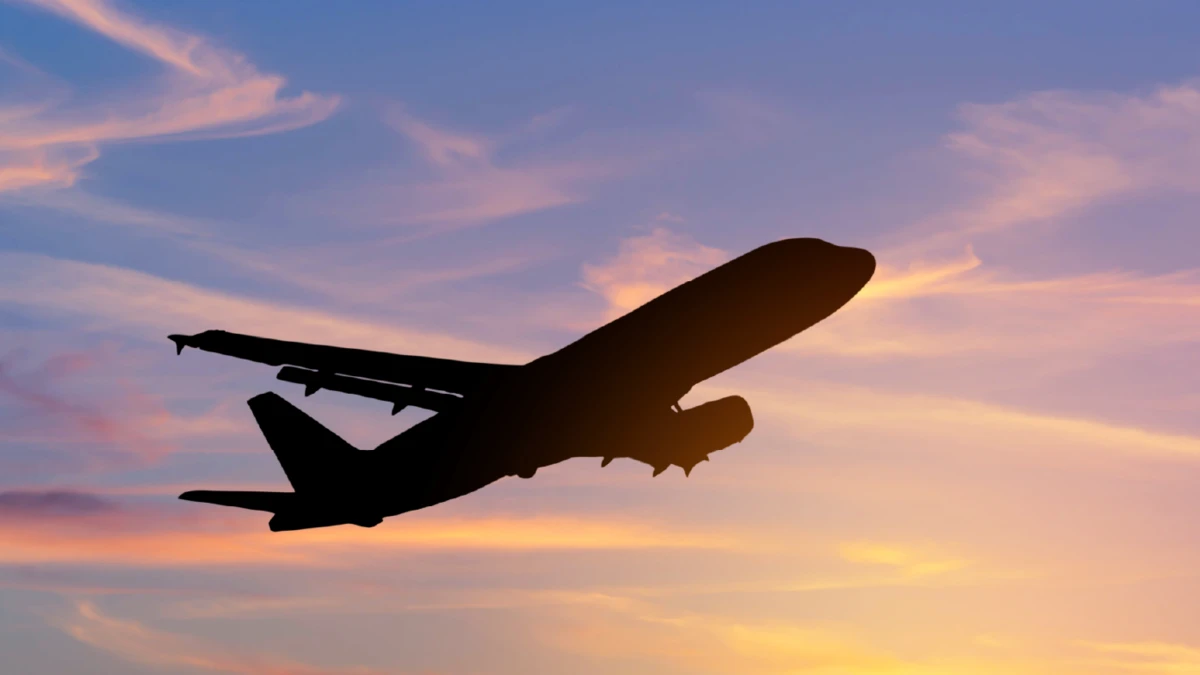 An aeroplane silhouetted against a sunset sky.