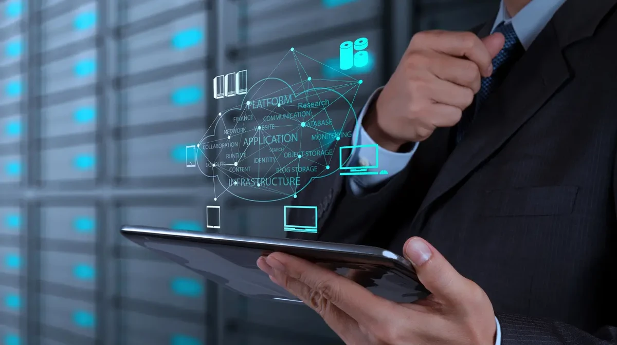 A businessman working on a tablet with computing cloud concepts.