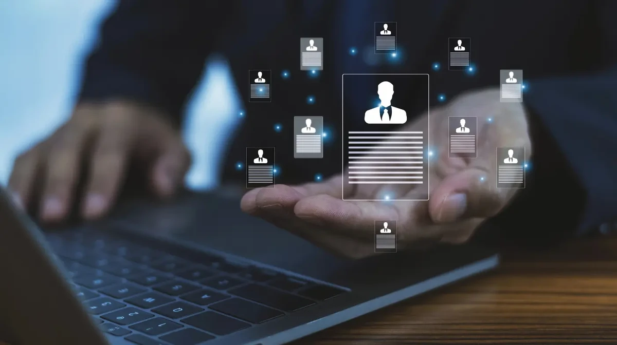 A businessman is working on a laptop with customer data network concepts.