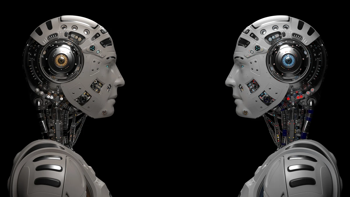 Two futuristic robots looking at each other. Two identical cyborgs. Isolated on black background.