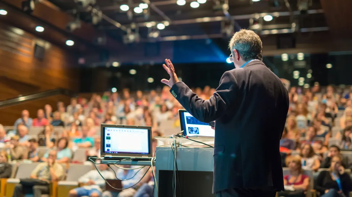 A speaker in an event is talking to an audience of event participants