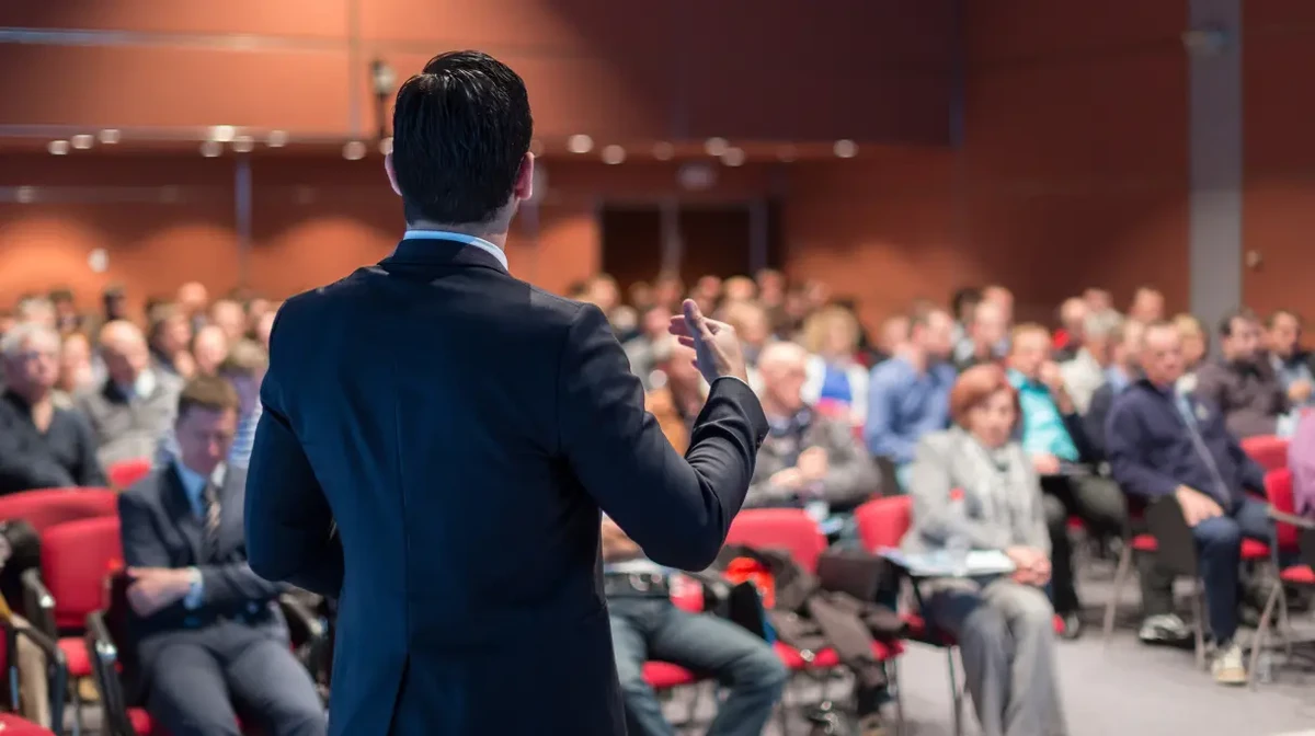 A speaker in an event is talking to an audience of event participants