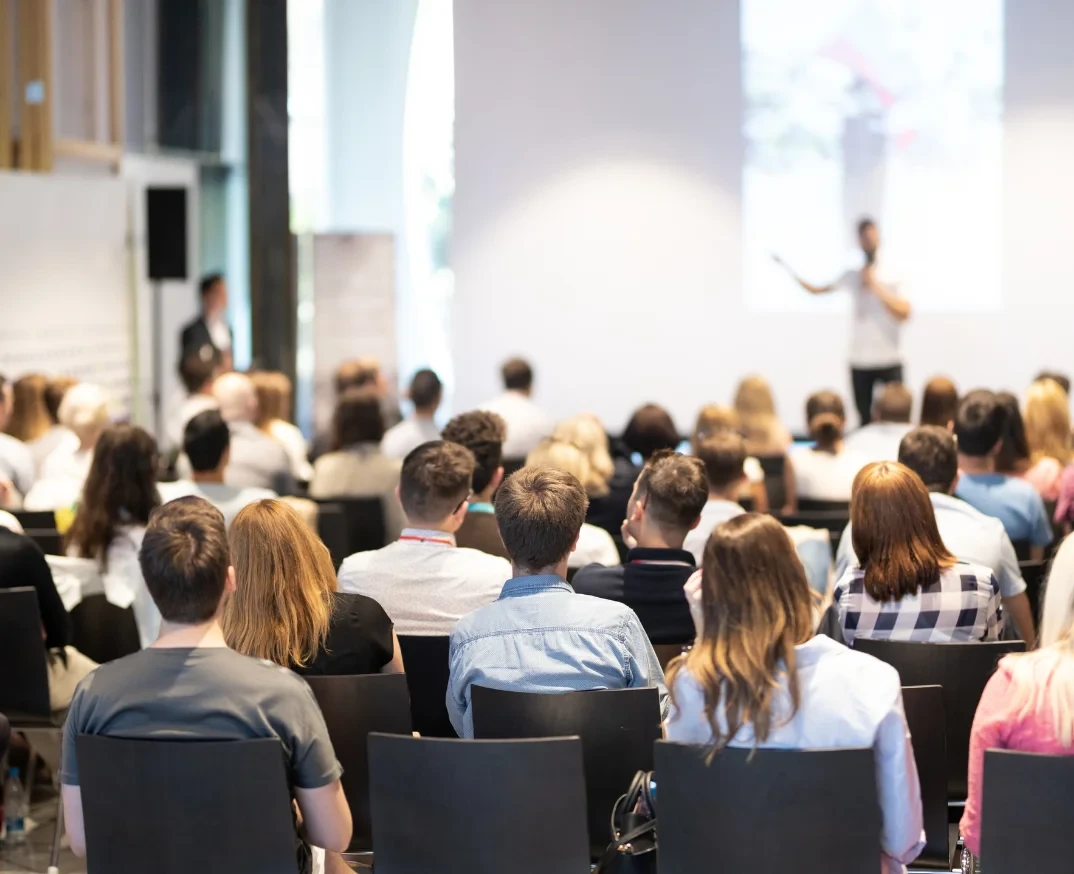 An speaker is talking to a crowd of partcipants in a tech conference