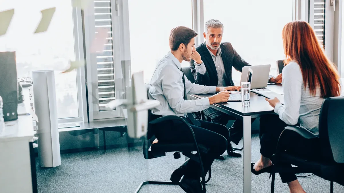 A managemnet team comparing different technological approaches in an office