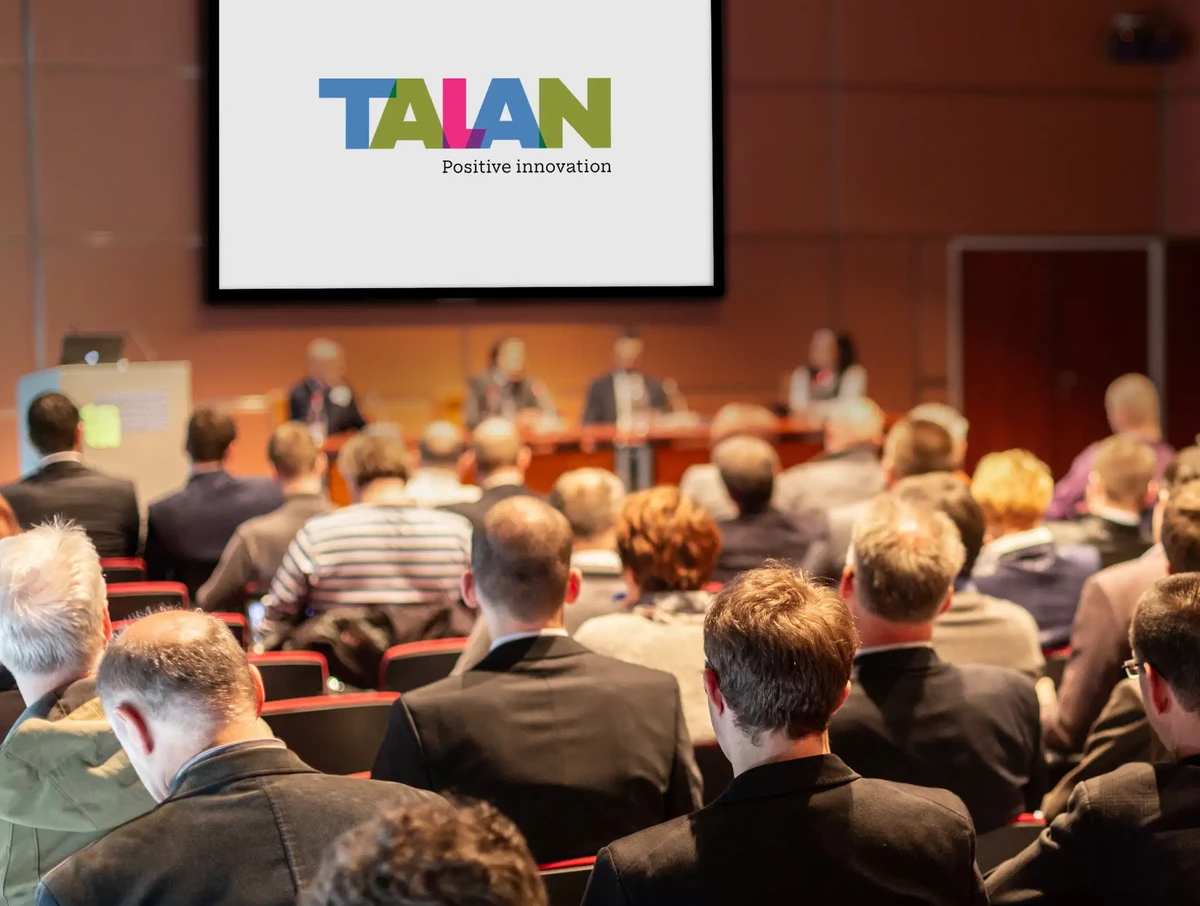 Event participants listening to a presentation by a Talan expert