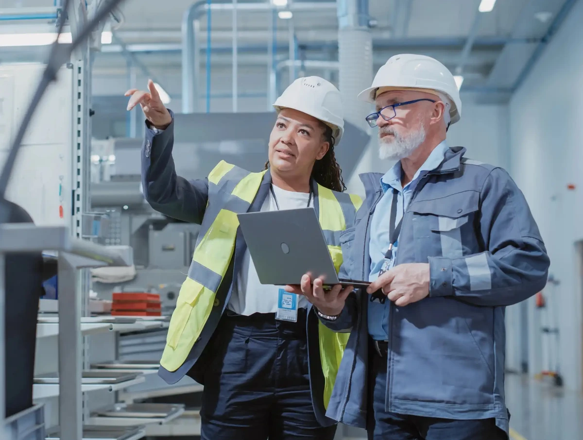 Two Heavy Industry Employees in Hard Hats at Factory.