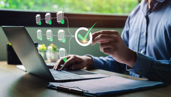Businessman using laptop doing online data quality checklist survey