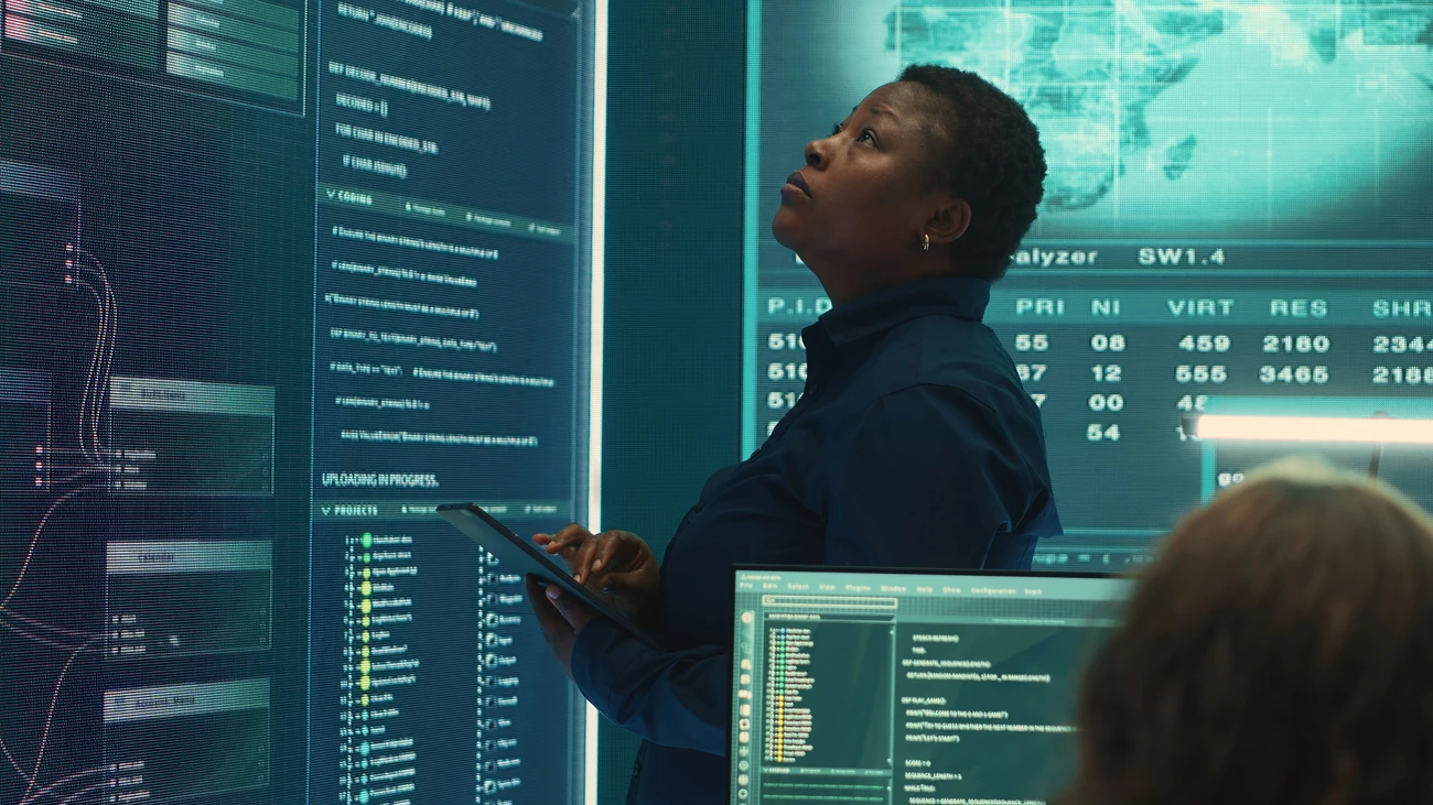 Female IT Expert analysing data on a big screen