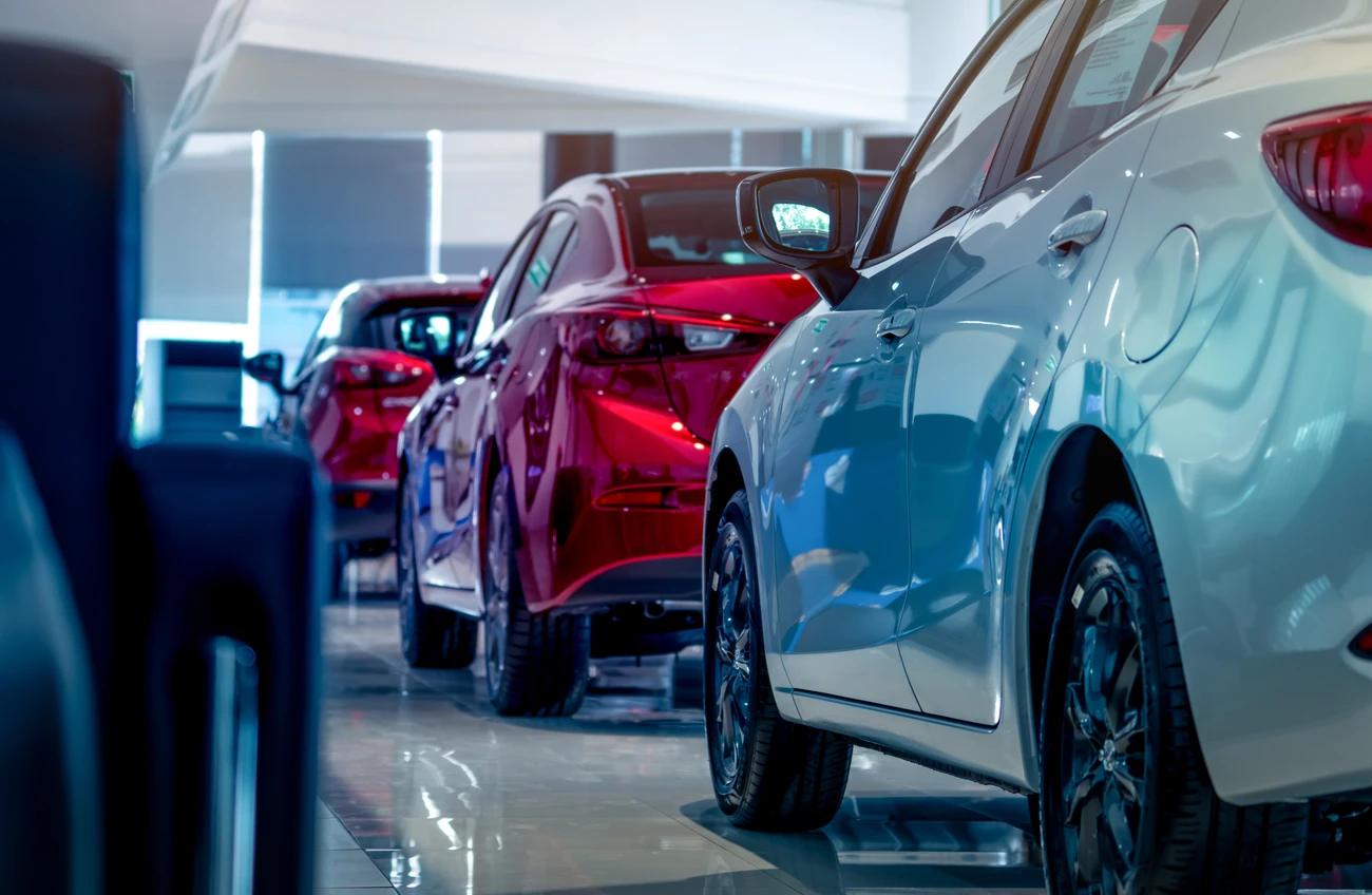 Rear view of new luxury red and white car parked in modern show room. 