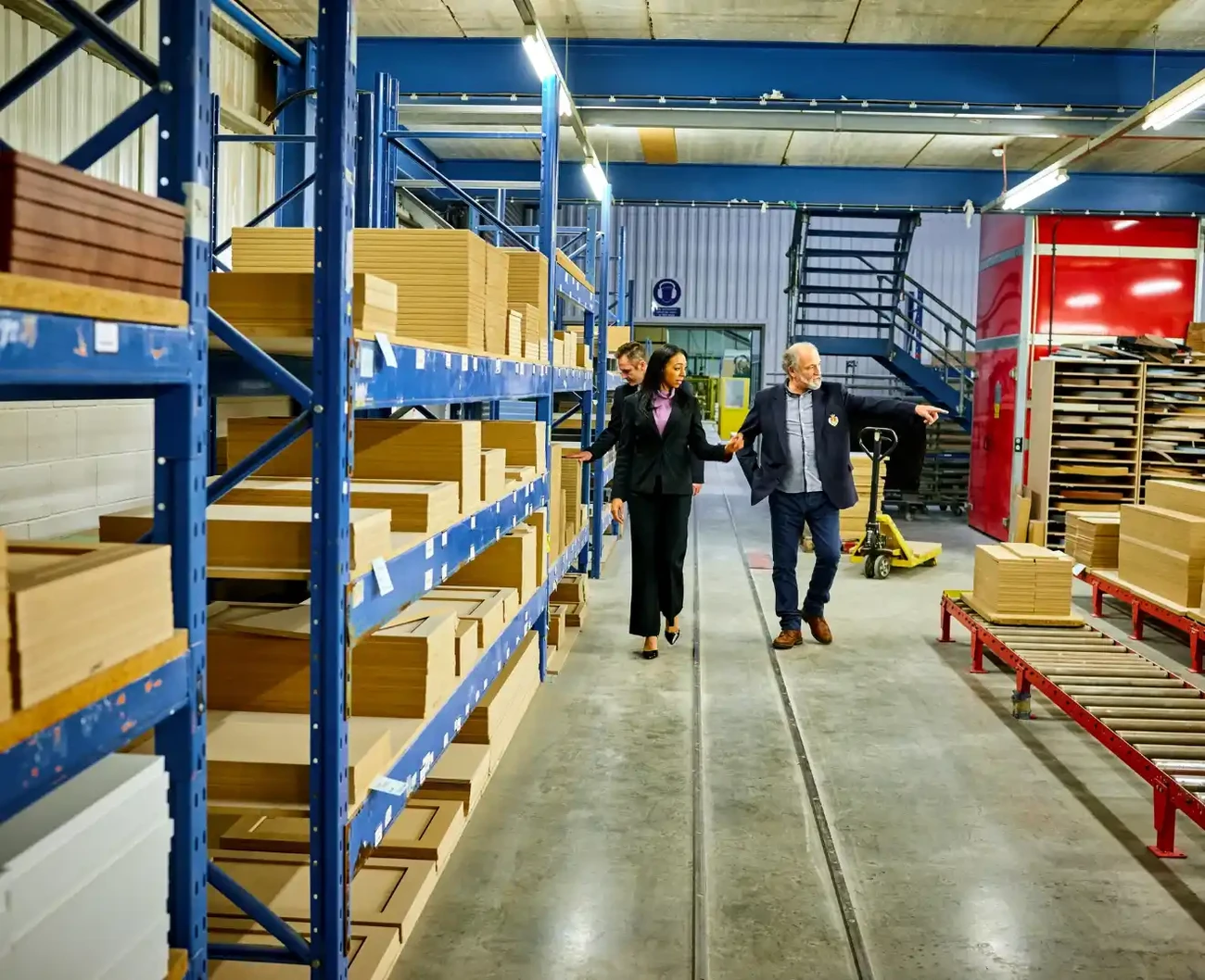Two business managers walk an organized shop floor and inspect the process