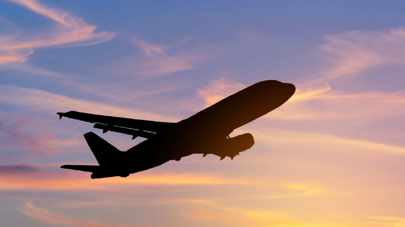 An aeroplane silhouetted against a sunset sky.