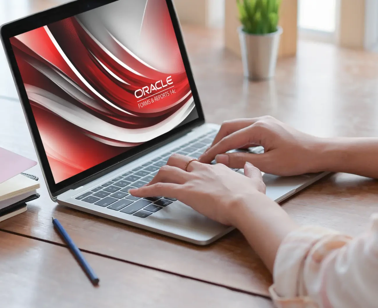 A man is working on a laptop with the preview of Oracle 14c opened