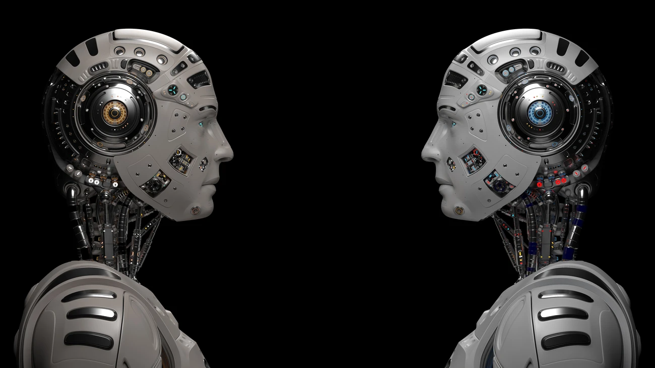 Two futuristic robots looking at each other. Two identical cyborgs. Isolated on black background.