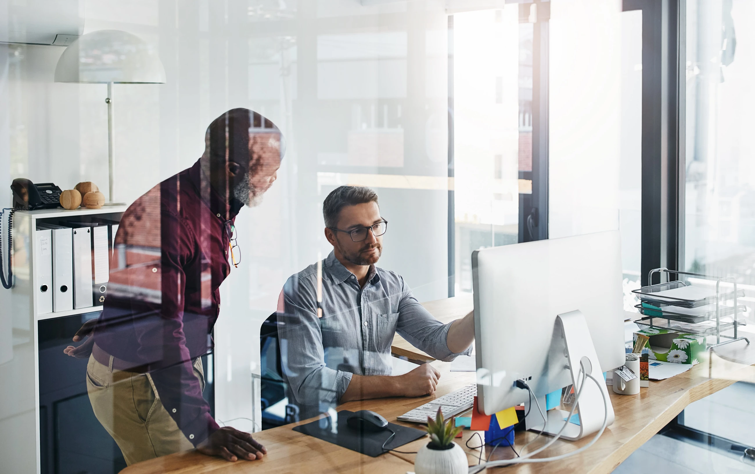 Two people looking at the computer screen at the Microsoft Dynamics 365 Business Central