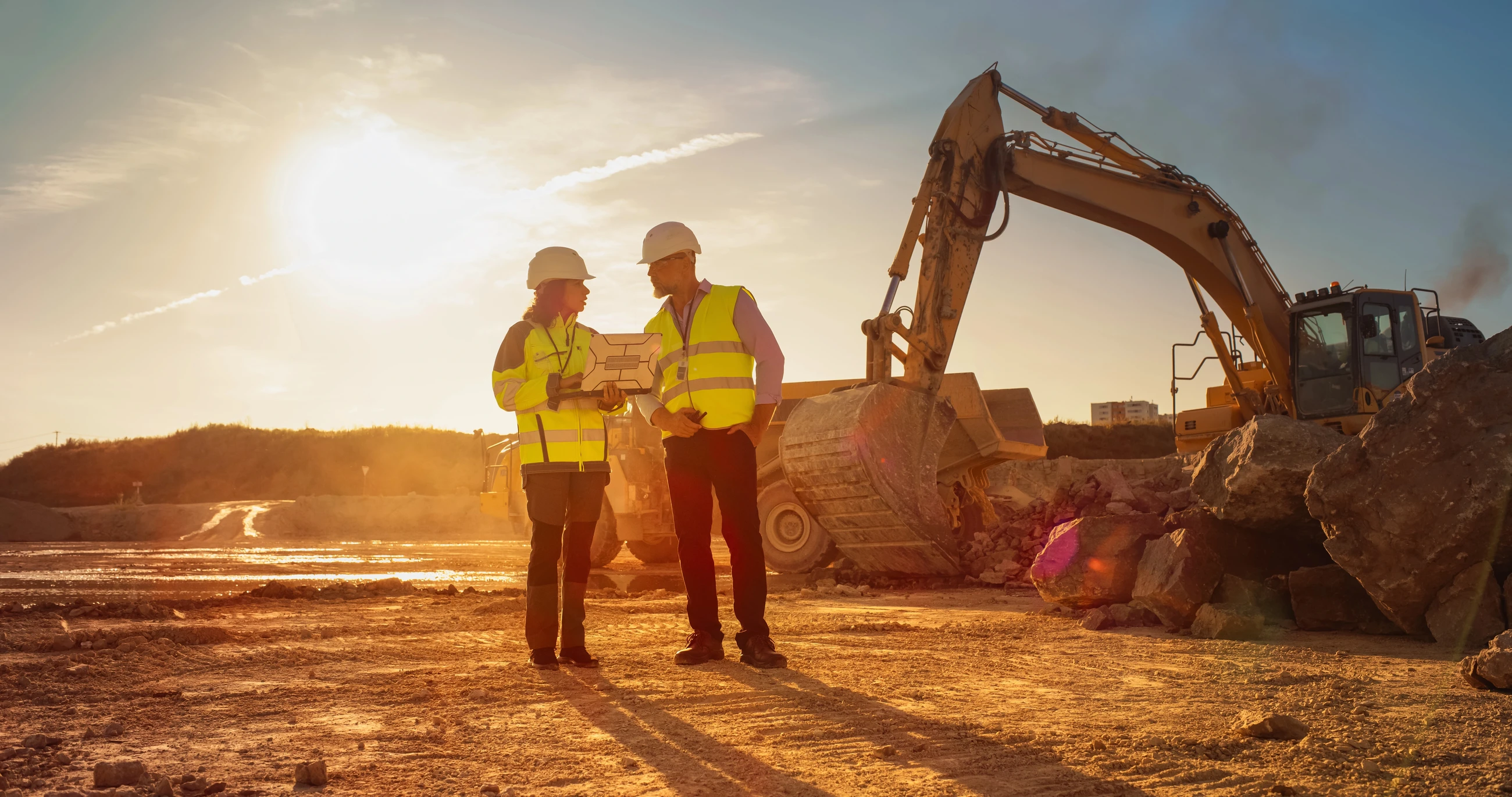 Mining industry thumbnail: Two workers on a mining site look at some information on a laptop 