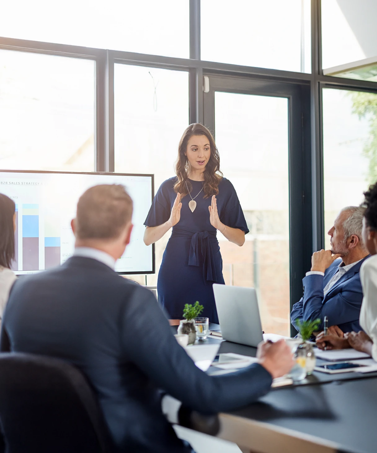 Woman in front of a group of professional people talking about faster and smarter closing with Talan and SAP Finance for Group Reporting.