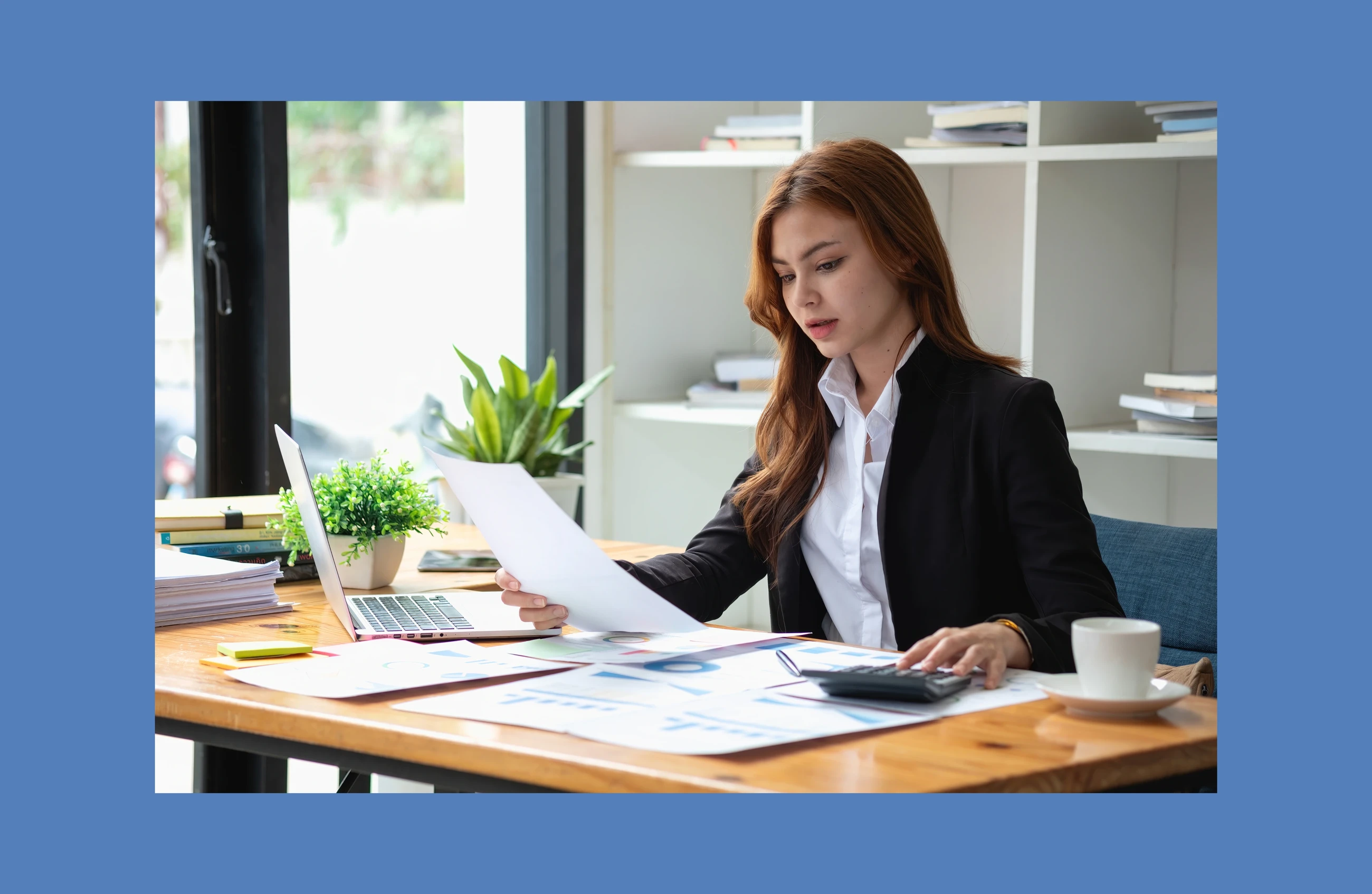 A woman in an office looks at some financial data on a paper