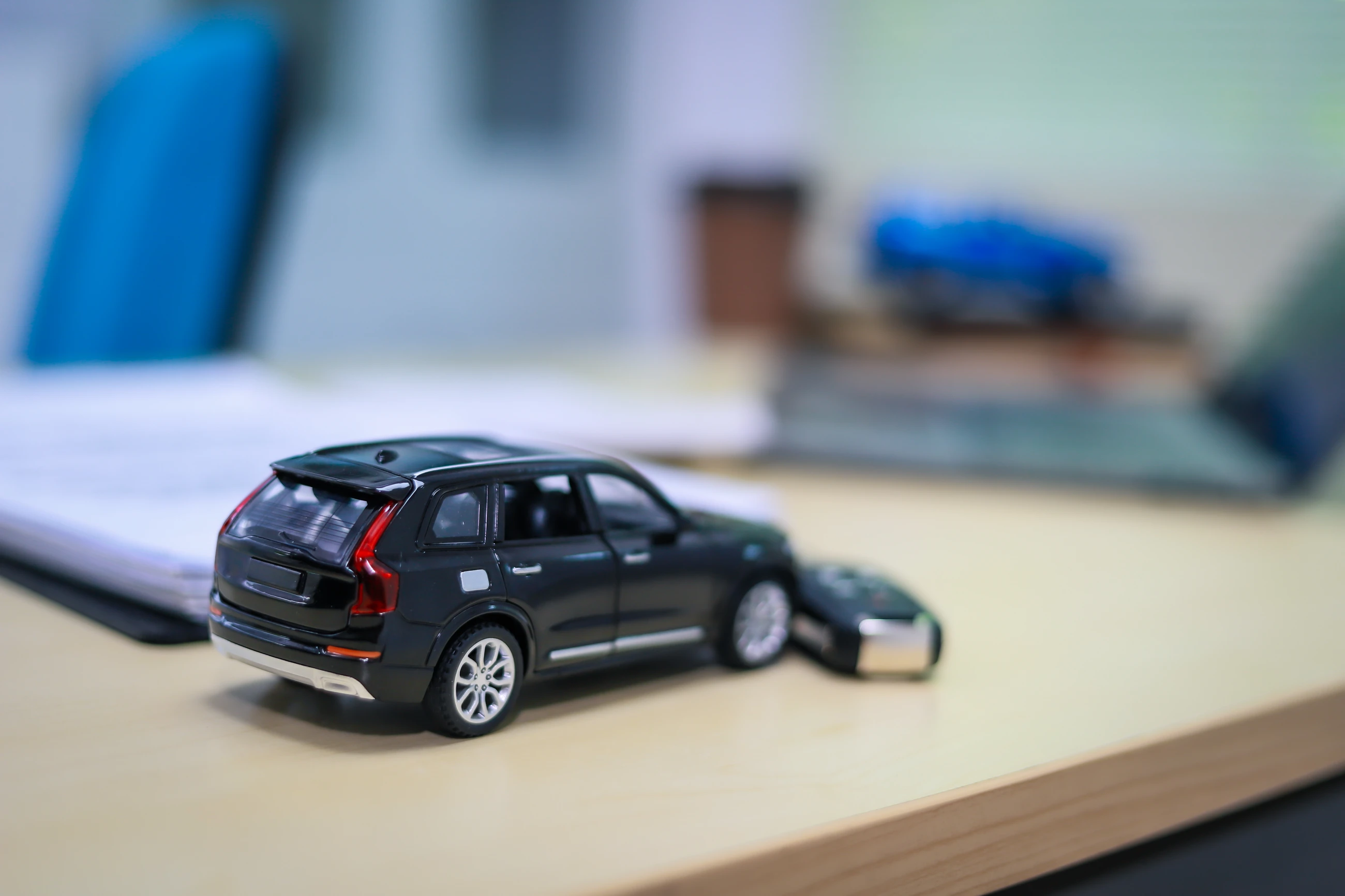 A businessman is working at his desk, focused on car financing, car sales, and insurance. He is analyzing customer data related to automobile financing.