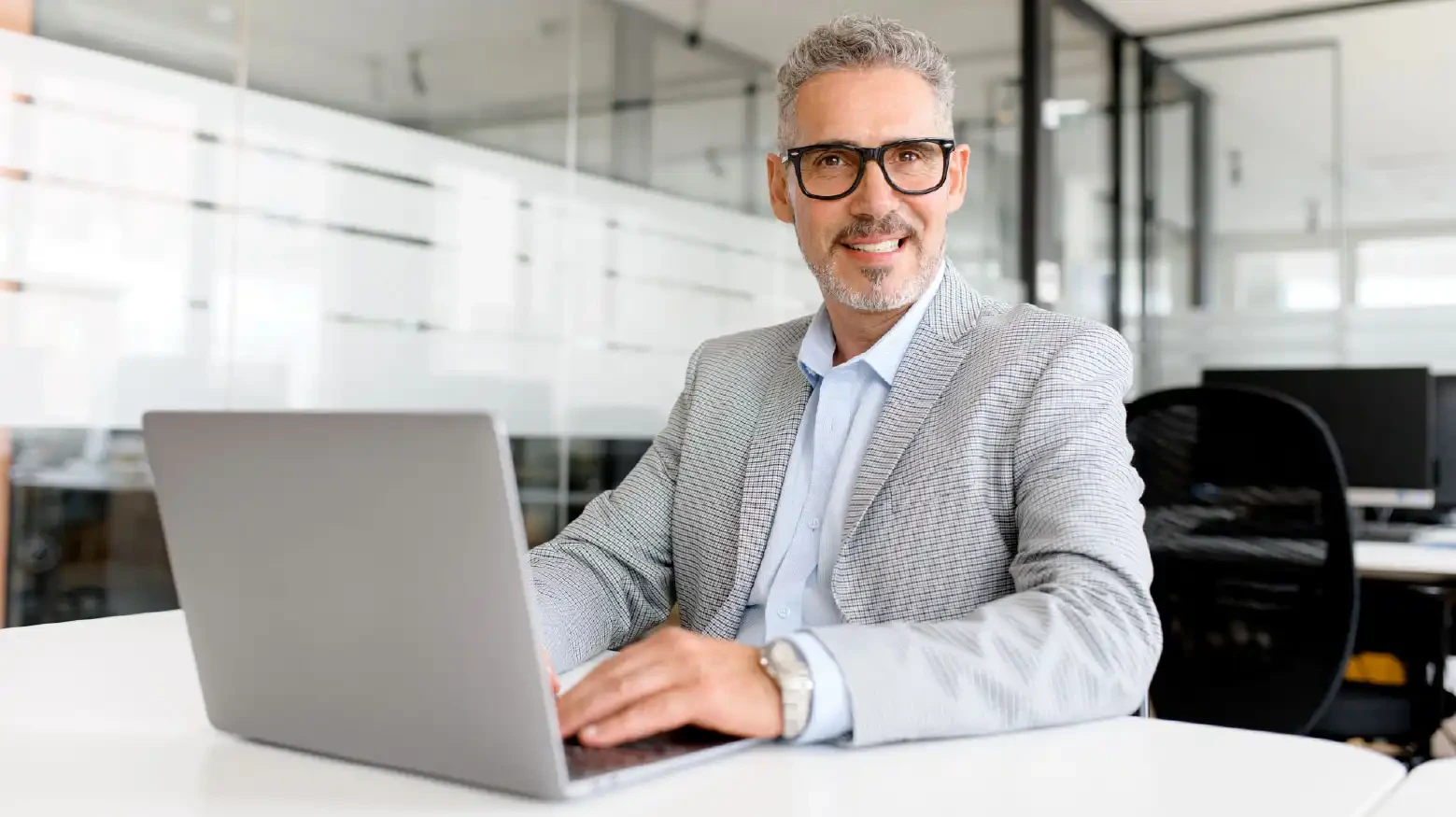 Man CIO ensuring that your current systems evolve with new business requirements on computer in office.