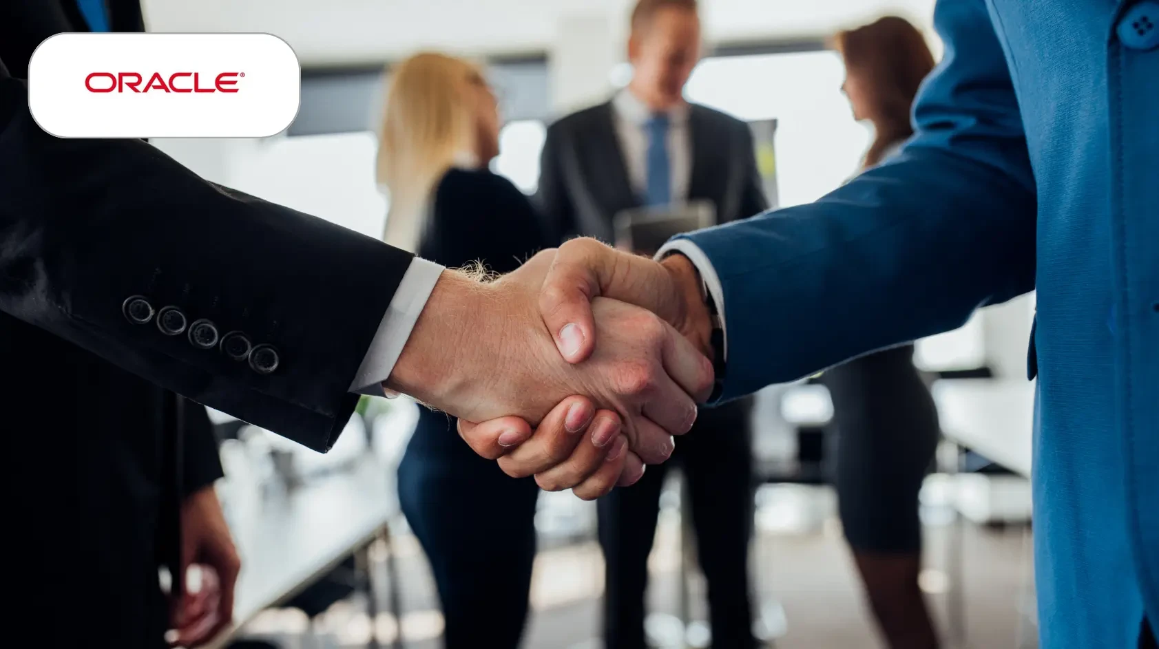 Two people in a business environment shake hands to finalize a deal