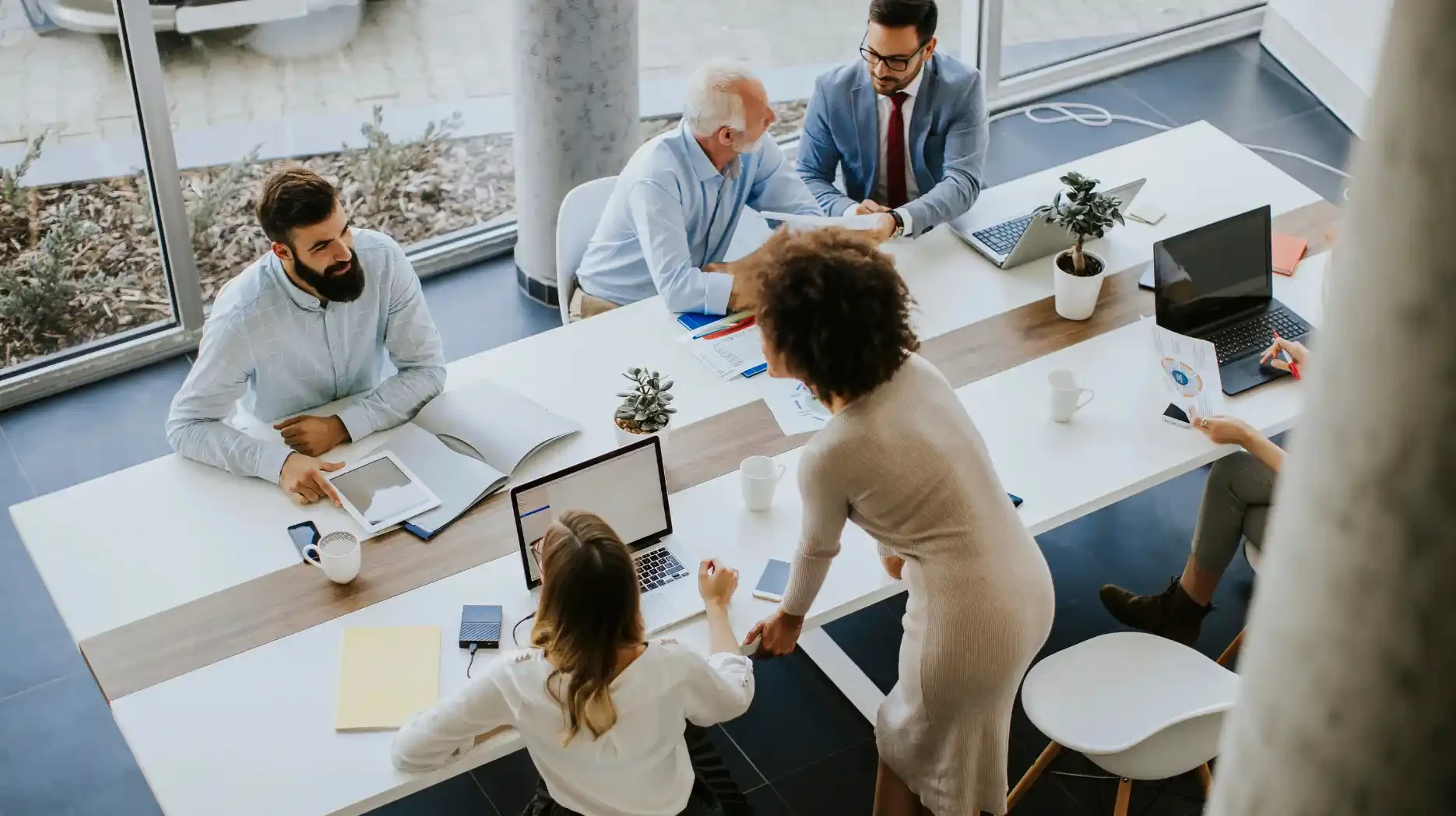 A dynamic senior development team gathers around a table to discuss some strategic customer information