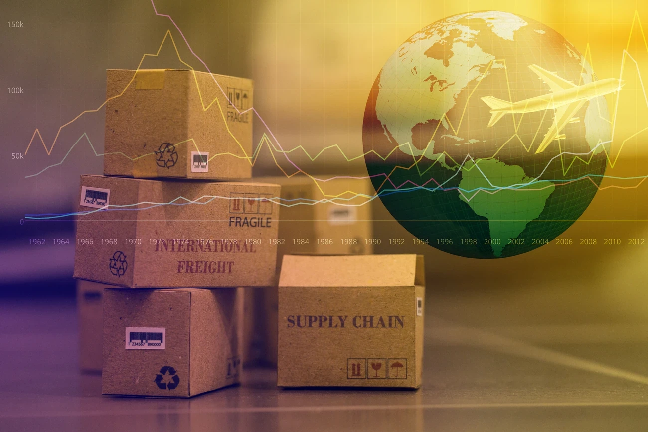 Small cardboard boxes with a plane flying above a world map.