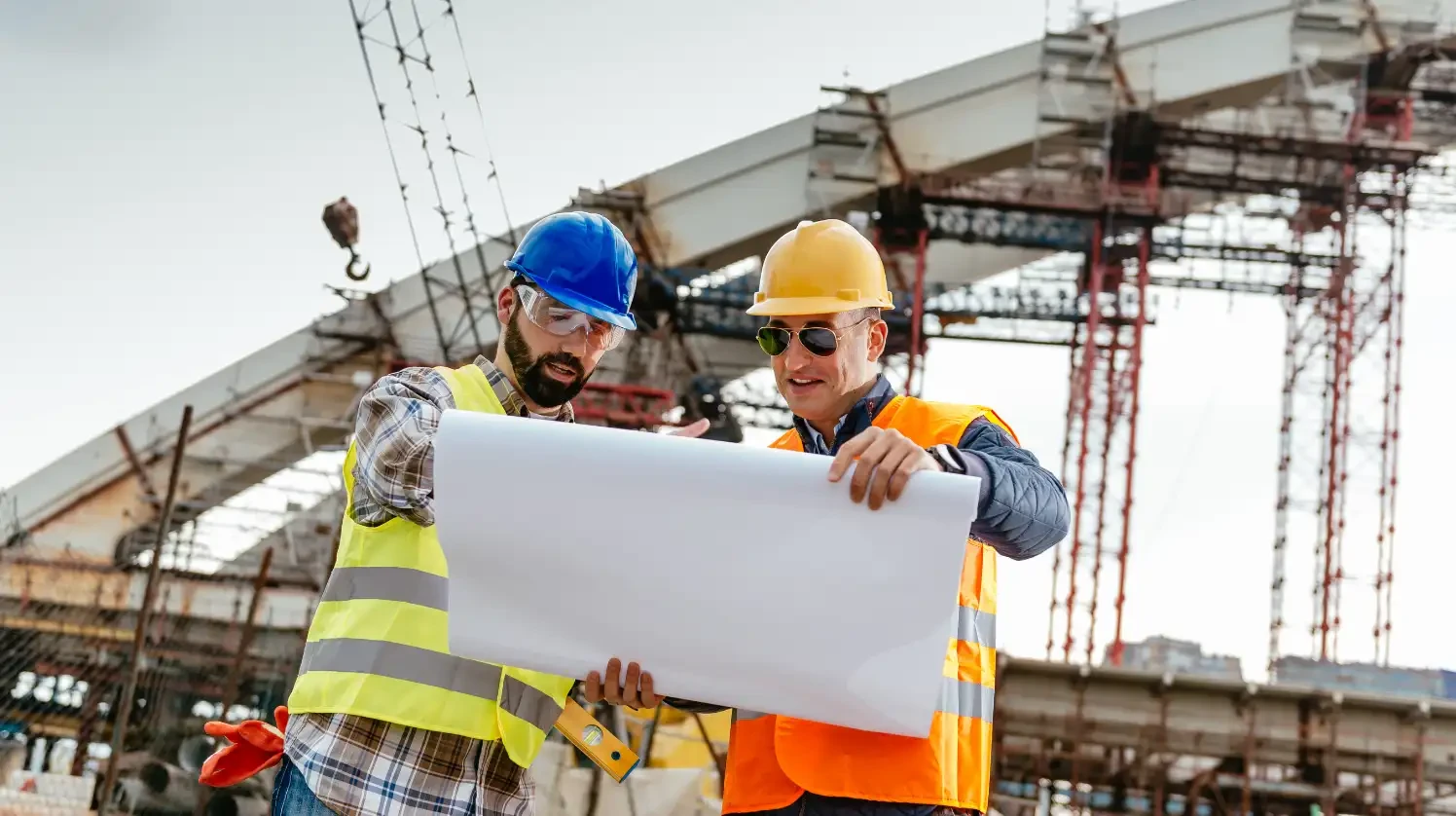 Engineers and architects on a construction site with blue prints and digital software for better calcualtion and organization
